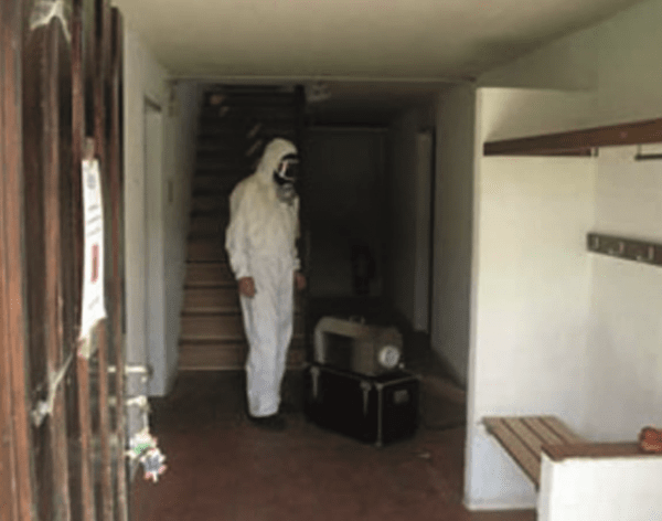 Tatortreiniger im Aspestanzug bei der Arbeit